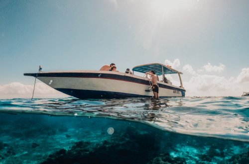 An underwater shot of a boat on the clear blue water with a blue sky in Bali 